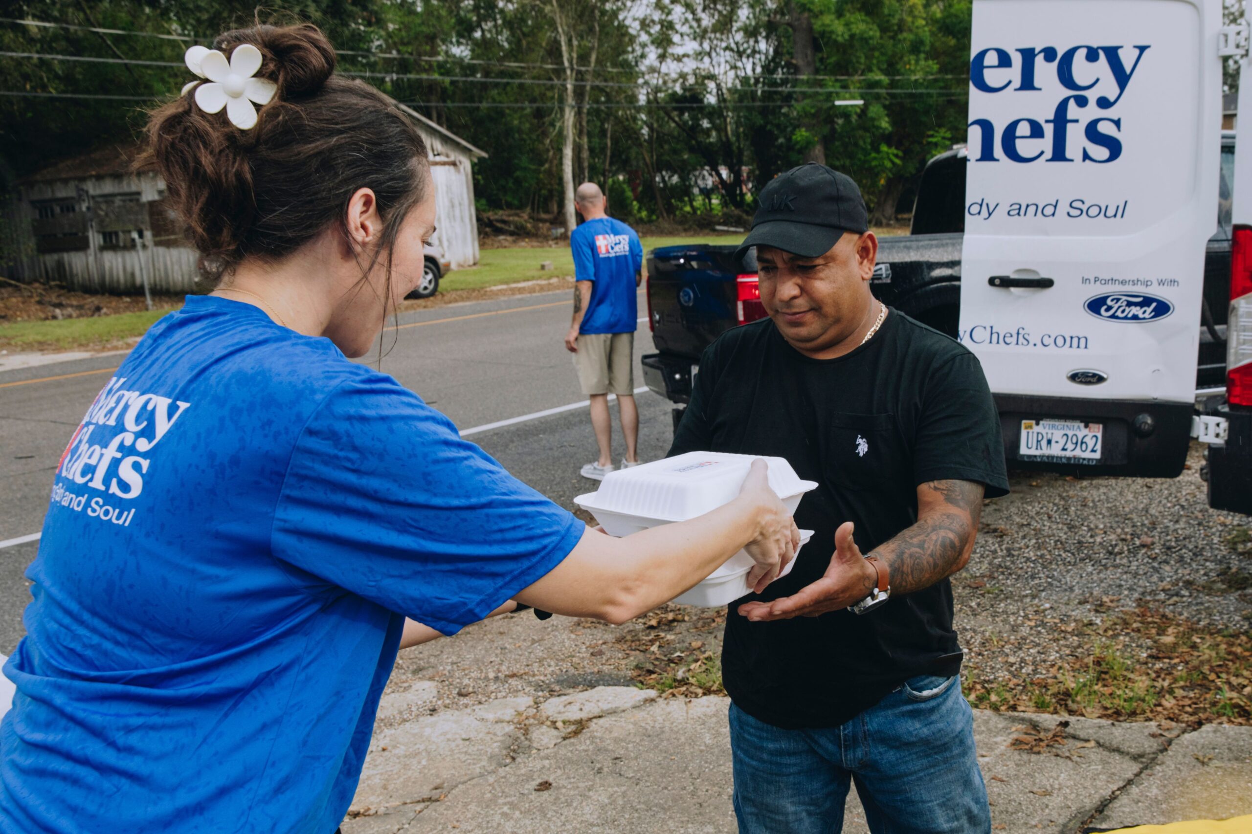 Volunteer serving a Mercy Chefs meal to Hurricane Francine victim