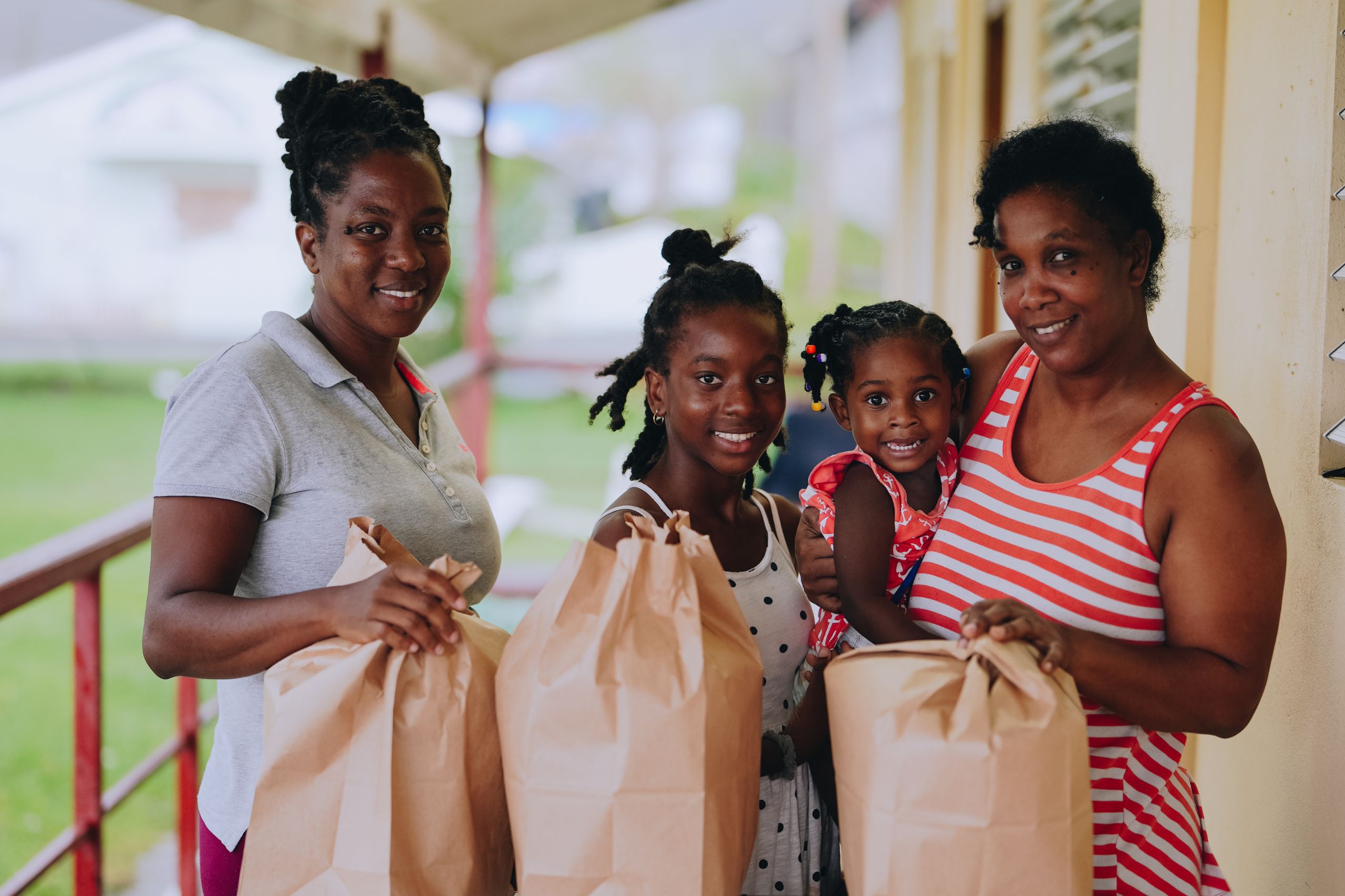 Family receiving groceries in Grenada after Hurricane Beryl