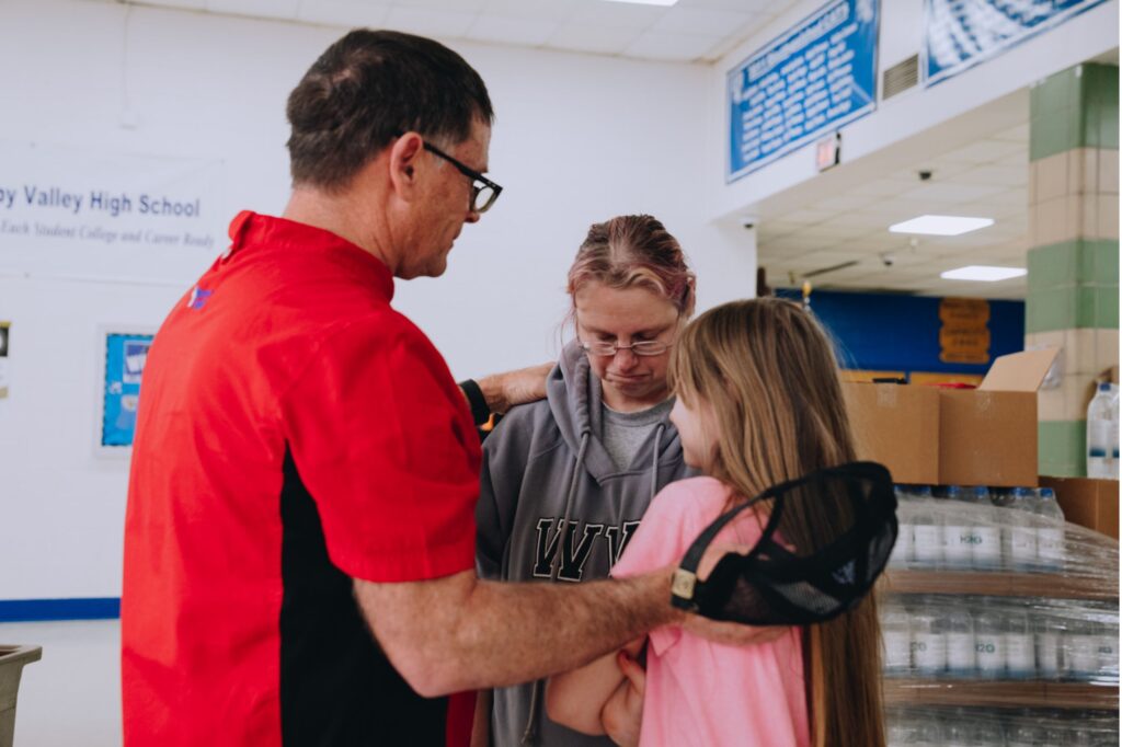 Chef John prays over Sherry and Willow in Kentucky.