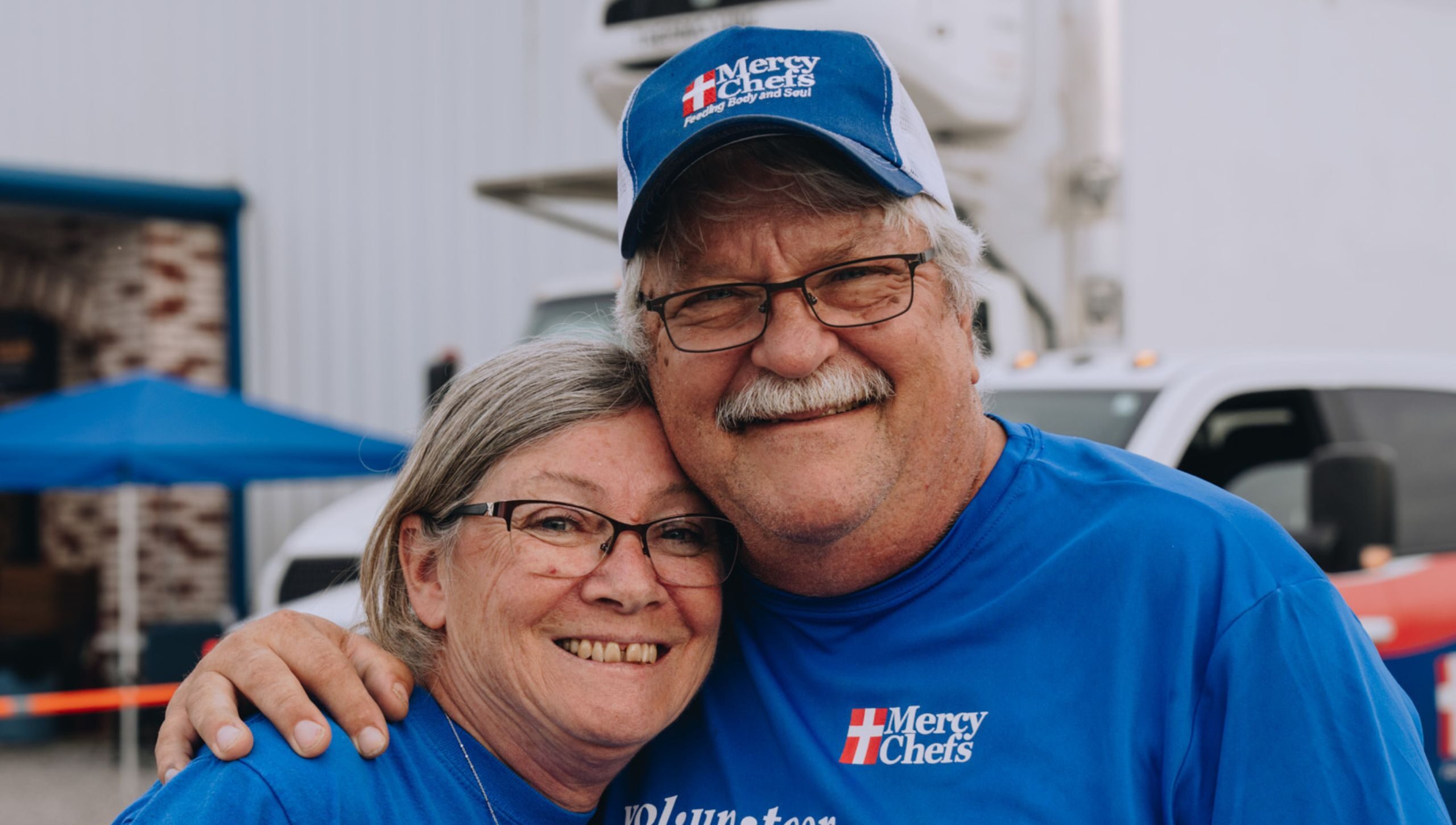 Husband and wife volunteering at Mercy Chefs.