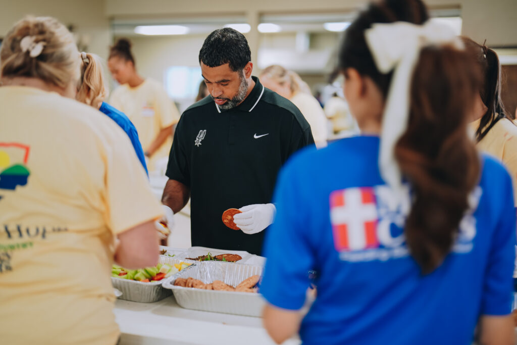Spurs General Manager Brian Wright preparing meals for Texas flood victims