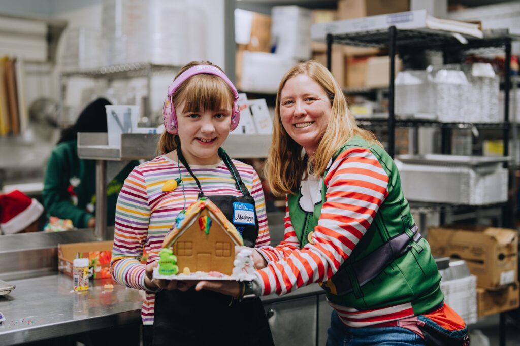 A mother and daughter holding their gingerbread house at the Portsmouth Community Kitchen