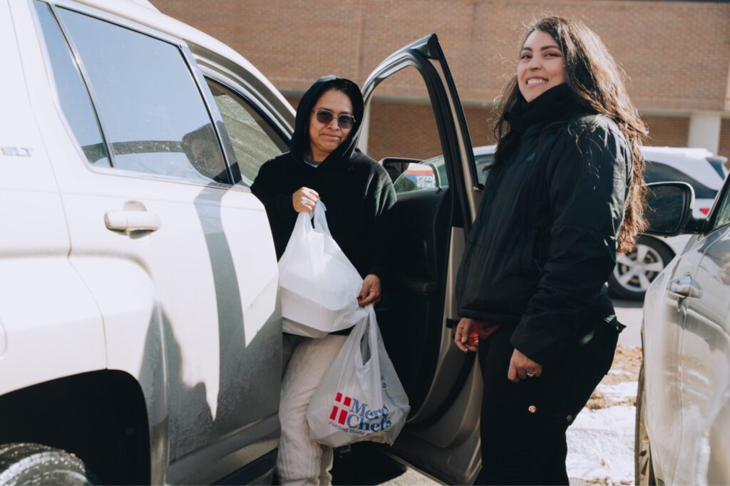 A Mercy Chefs partner hands hot meals to a winter storm victim in Nashville, TN, for her family