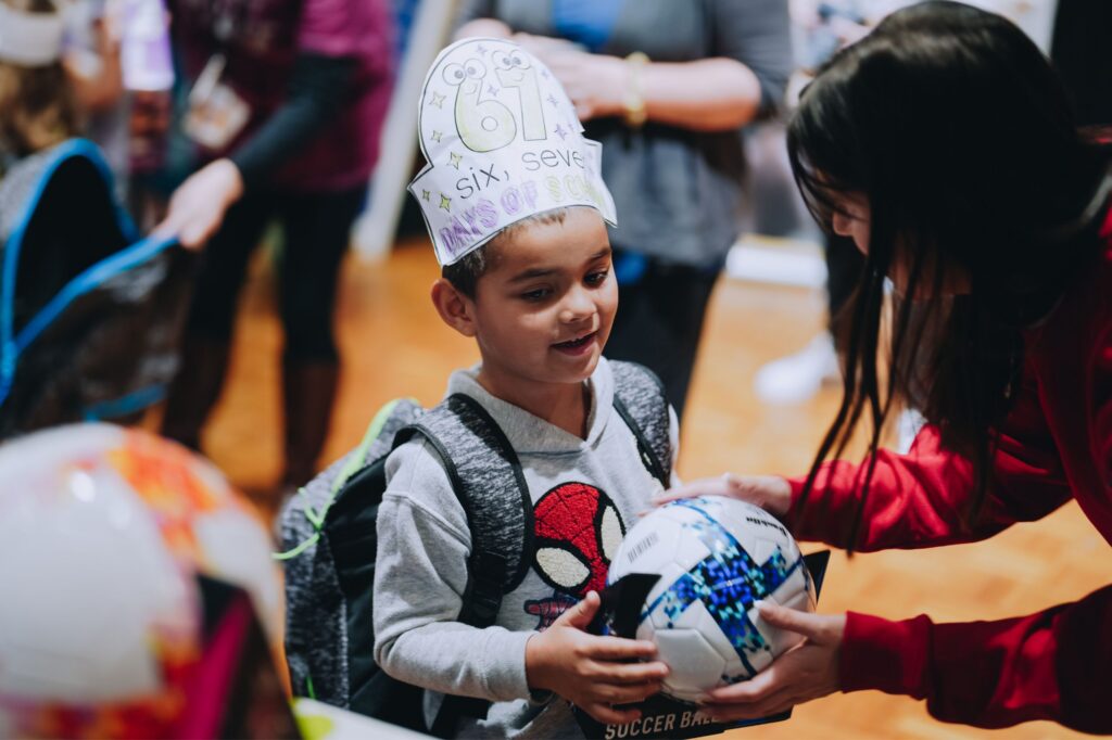 An elementary school boy receives a backpack and soccer ball in North Carolina