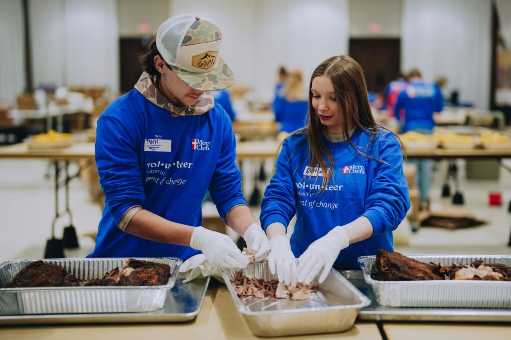 Two volunteers in Monroe, LA, prepare meals for winter storm victims