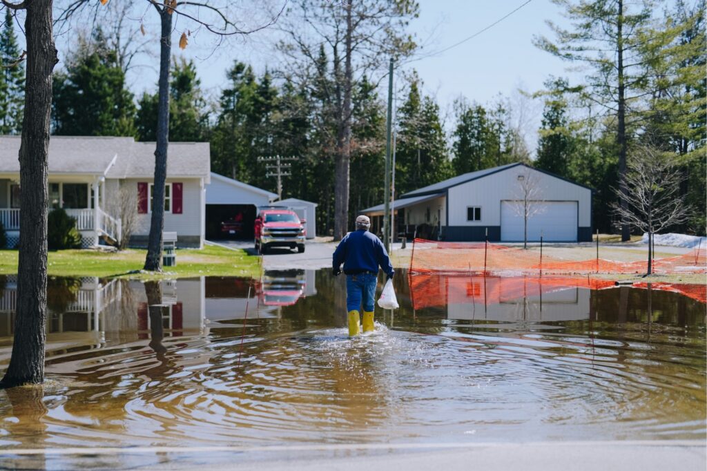 A man cross a flooded neighbor hood in Michigan