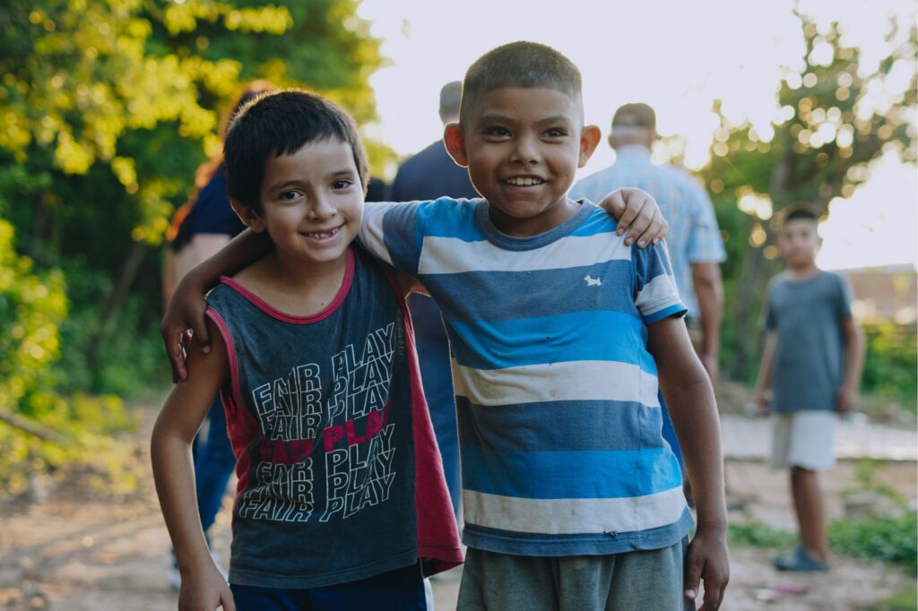 Two young boys in Argentina smile and hug each other