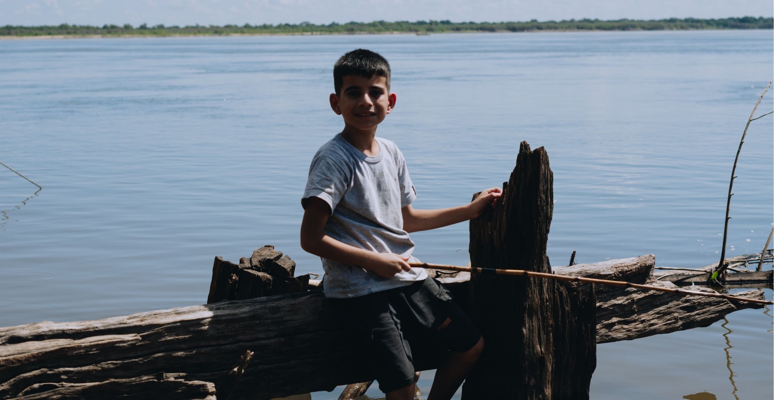 A child smiles as he fishes in Argentina