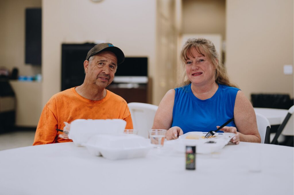 A couple smile as they enjoy a Mercy Chefs meal